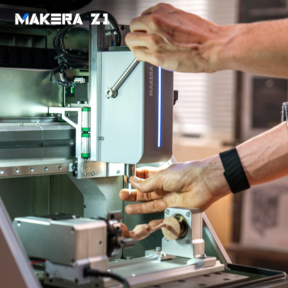 Changing a cutting tool on the Makera Z1 desktop CNC mill with a wooden workpiece secured in the fourth-axis module.