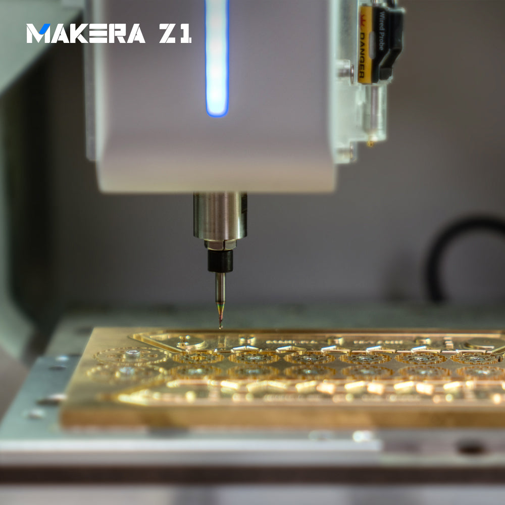 Makera Z1 desktop CNC mill engraving intricate relief details into a brass plate.